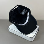 Black distressed cotton cap with metal graphic and glossy shield brim